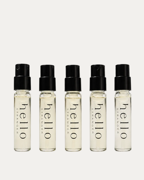 Five small glass bottles with black caps labeled 'hello' on a light gray background